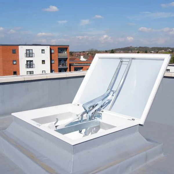 An open rooftop access hatch with metal support in a modern residential area, surrounded by buildings. The sky is clear, conveying a clean, urban setting.